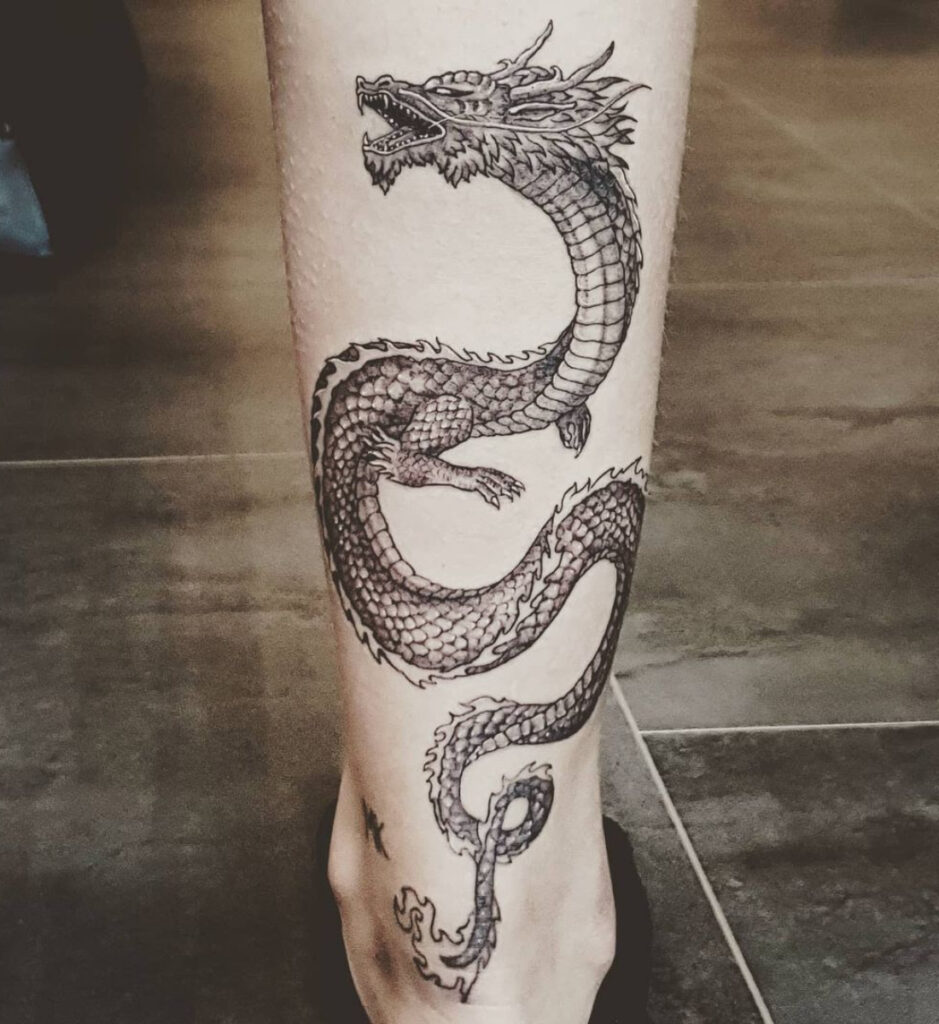 Lijnwerk tattoo van een sierlijke oosterse draak op het onderbeen
