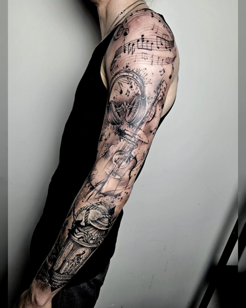 Volledige armsleeve tattoo met muzikale elementen zoals notenbalken, koptelefoon, viool en klok, gezet in realistische stijl