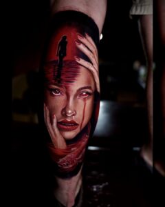 Tattoo met vrouwengezicht, rode tranen, hand, silhouet in water en vis in surrealistische stijl, uitgevoerd bij Tat2holics in Den Haag