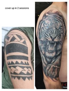 Voor-en-na tattoo cover-up: tribal ontwerp op bovenarm vervangen door realistische tijgerkop met blauwe ogen, uitgevoerd bij Tat2holics in Den Haag