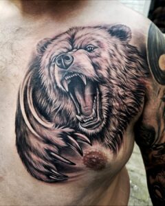 Tattoo van een brullende beer op de borst, realistisch uitgewerkt met schaduw en dynamiek