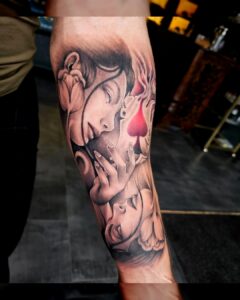 Tattoo op onderarm in manga-realistische stijl met vrouwelijke gezichten en speelkaartdetails